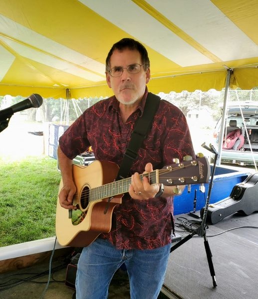 Craig playing guitar at a local music festival